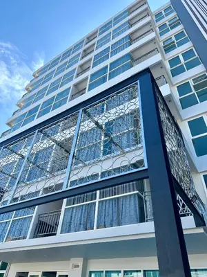 a tall building with a lot of glass windows at Phuket Kata Studio Apartment in Kata Beach