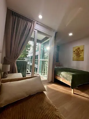 a bedroom with two beds and a large window at Phuket Kata Studio Apartment in Kata Beach