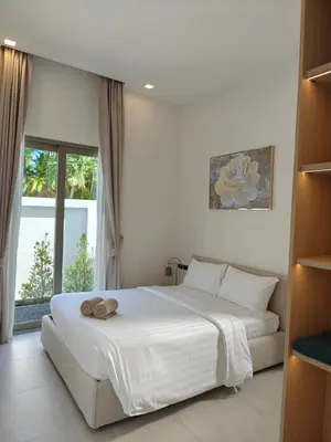 a bedroom with a large white bed and a window at V-004 4 BR Unique Villa Baan Bua in Rawai Beach