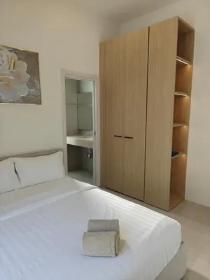 a bedroom with a white bed with a wooden cabinet at V-004 4 BR Unique Villa Baan Bua in Rawai Beach
