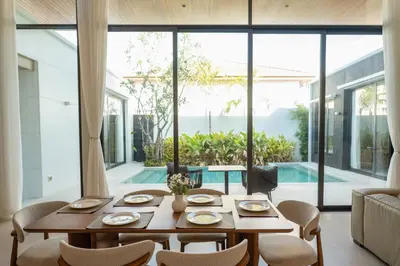 a dining room with a table and chairs and a large window at Holiday pool villa in Ban Na Nai