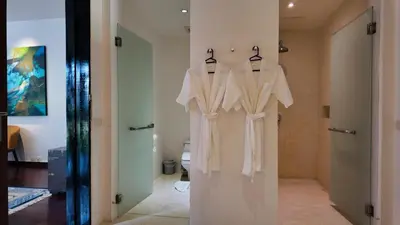 a bathroom with two white shirts hanging on a wall at Villa Samakee Luxury 5 Bedroom Villa in Ban Thalat Choeng Thale