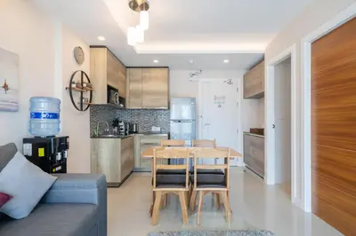 a kitchen and dining room with a table and chairs at 1 BR Balcony Pool and Garden View - Babylon Sky M206 in Rawai Beach