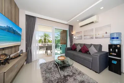 a living room with a couch and a tv at 1 BR Balcony Pool and Garden View - Babylon Sky M206 in Rawai Beach