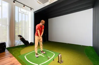 a man playing golf in a room with a golf ball at Bangtao Premium 2BR Apartment, Title Legendary B201 in Bang Tao Beach