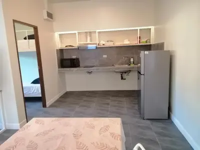 a kitchen with a counter and a refrigerator at TwinVillaSky in Ban Muang Mai