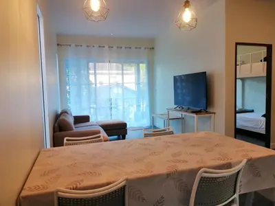 a living room with a table with chairs and a television at TwinVillaSky in Ban Muang Mai