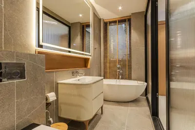 a bathroom with a white tub and a sink at PRAIA Residence 4BR - Bangtao in Ban Pak Lak