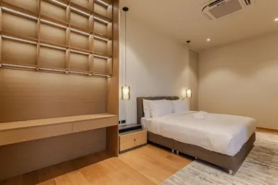 a bedroom with a bed and a walk in closet at PRAIA Residence 4BR - Bangtao in Ban Pak Lak