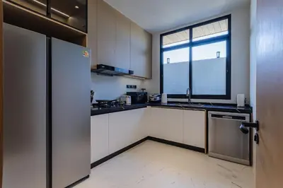 a kitchen with a refrigerator and a window at PRAIA Residence 4BR - Bangtao in Ban Pak Lak