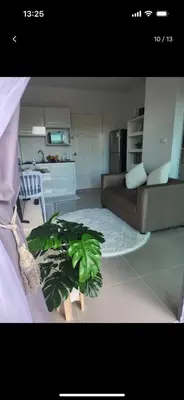 a living room with a couch and a plant at Charming Condo in Wichit Comfort Meets Convenience in Ban Rangeng