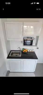 a small kitchen with a sink and a microwave at Charming Condo in Wichit Comfort Meets Convenience in Ban Rangeng
