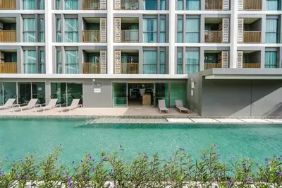 an external view of a building with a swimming pool at 1BR Ozon BangTao apartment in Laguna Phuket