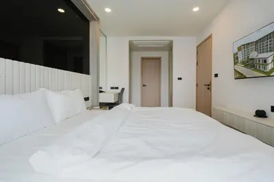 a bedroom with a white bed and a desk at 1BR Ozon BangTao apartment in Laguna Phuket