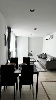 a living room with a table and chairs and a couch at Centrio 2 bed rooms 52 in Ban Lo Long