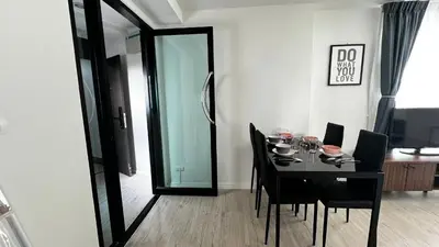 a dining room with a table with chairs and a mirror at Centrio 2 bed rooms 52 in Ban Lo Long