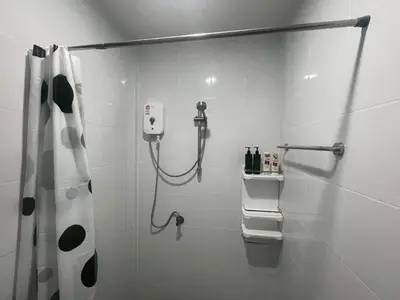 a white bathroom with a shower and a shower curtain at Joyful House in Ban Dan