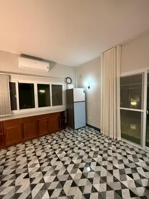 a kitchen with a black and white checkered floor at Joyful House in Ban Dan