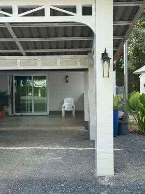 a white bench sitting on the porch of a house at Joyful House in Ban Dan