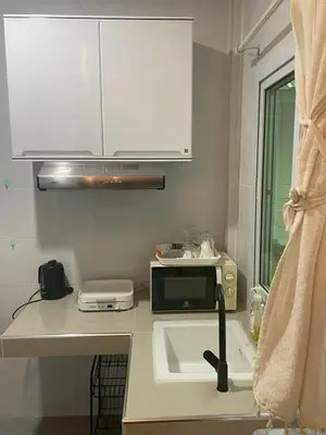 a kitchen with a sink and a microwave at Joyful House in Ban Dan