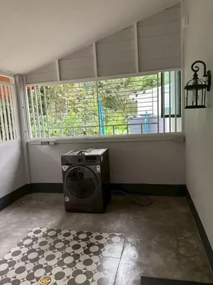 a room with a washing machine in a room with a window at Joyful House in Ban Dan
