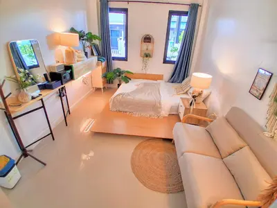 a living room with a bed and a couch at Bimi warm house in Ban Na Sat