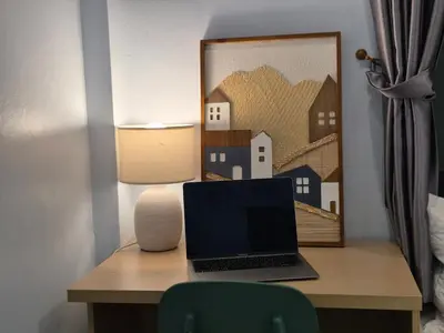 a laptop computer sitting on a desk with a lamp at Bimi warm house in Ban Na Sat