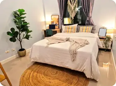 a bedroom with a large white bed and a rug at Bimi warm house in Ban Na Sat
