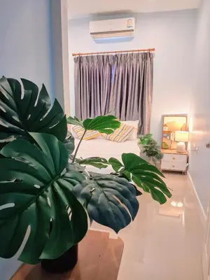 a bedroom with a bed and a potted plant at Bimi warm house in Ban Na Sat