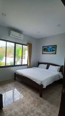 a bedroom with a large white bed with windows at Janjira sea view pool villa in Ban Ko Kwang