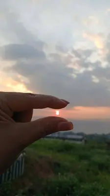 a hand is pointing at the sunset at Janjira sea view pool villa in Ban Ko Kwang
