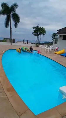 a couple of people laying in a large swimming pool at Janjira sea view pool villa in Ban Ko Kwang