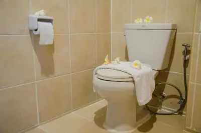 a bathroom with a toilet with a towel on it at SawasdeeCiao Patong Guesthouse in Patong Beach