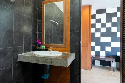 a bathroom with a sink and a mirror at SawasdeeCiao Patong Guesthouse in Patong Beach