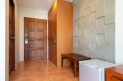 a hallway with a door and a table and a refrigerator at SawasdeeCiao Patong Guesthouse in Patong Beach