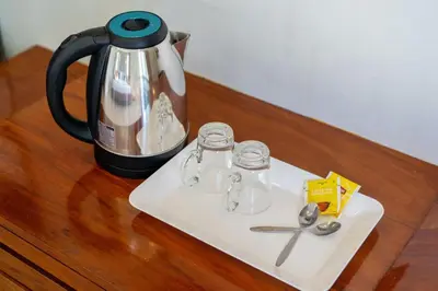 a coffee pot and a pair of scissors on a table at SawasdeeCiao Patong Guesthouse in Patong Beach
