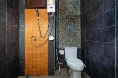 a bathroom with a shower with a toilet in it at SawasdeeCiao Patong Guesthouse in Patong Beach