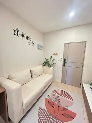 a living room with a white couch and a table at The Cust Phuket in Ban Khok Chang