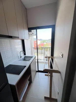 a kitchen with a sink and a view of a balcony at The Cust Phuket in Ban Khok Chang