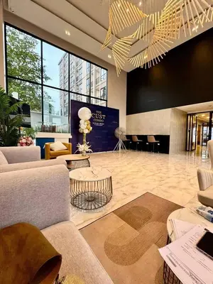 a lobby with couches and tables and a chandelier at The Cust Phuket in Ban Khok Chang