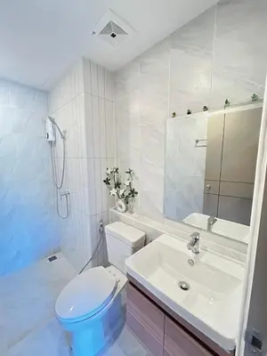 a white bathroom with a toilet and a sink at The Cust Phuket in Ban Khok Chang