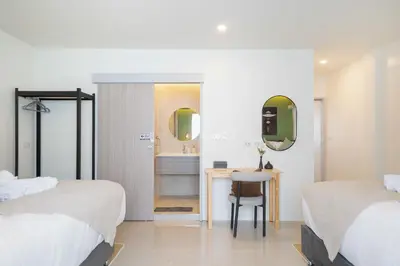 a bedroom with two beds and a desk with a mirror at Heaven pool villa reach beach in 3 mins bangla10m in Patong Beach