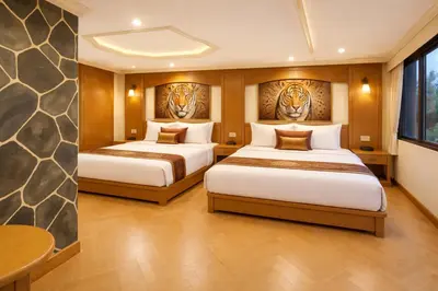 two beds in a room with two tigers on the wall at Tiger Complex Suites in Patong Beach
