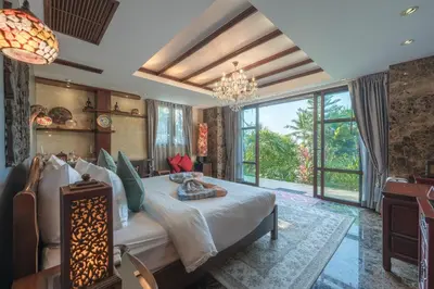 a bedroom with a large bed and a large window at Arun Rapee Villa Surin Beach in Surin Beach