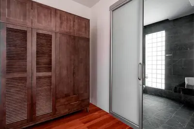 a bathroom with wooden cabinets and a sliding glass door at Mountain View 4BR Pool Villa Minutes to Kamala in Kamala Beach