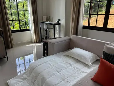 a bedroom with a bed and a couch and windows at Natureville cozy home near Samet Nangshe