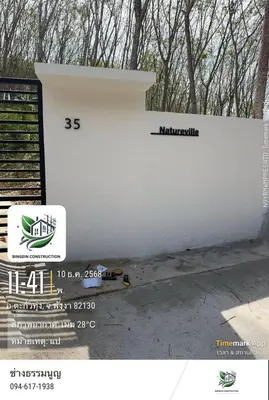 a white retaining wall with a sign on it at Natureville cozy home near Samet Nangshe