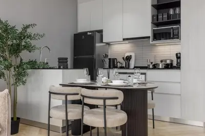 a kitchen with a table and stools in a kitchen at Safi 1BR Suite — The Title Legendary BangTao in Bang Tao Beach