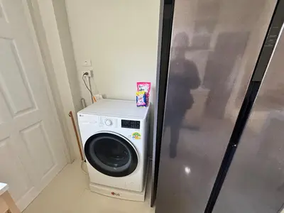 a washing machine sitting next to a refrigerator at Modern townhome in Phuket in Ban Phak Chit