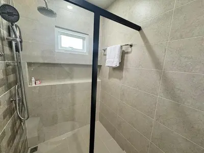 a shower with a glass door in a bathroom at Modern townhome in Phuket in Ban Phak Chit
